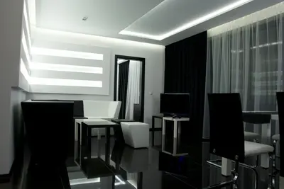 a living room with white chairs and a television at Hotel Fashion - Free Parking in Sofia