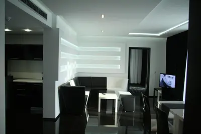 a living room with a table and chairs and a television at Hotel Fashion - Free Parking in Sofia