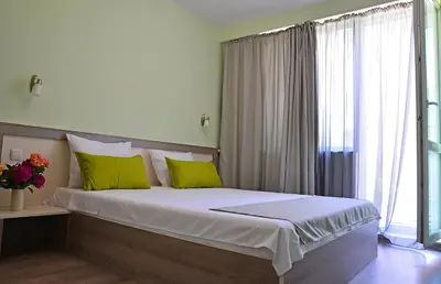 a bedroom with a large bed with green pillows at Visito Aparthouse in Sofia