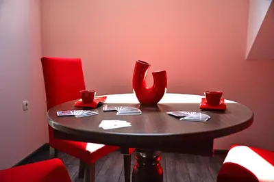 a table with red chairs and a red vase at Visito Aparthouse in Sofia