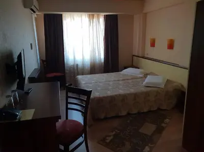 a hotel room with a bed and a table and chair at Hotel Diavolo in Sofia