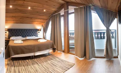 a bedroom with a bed and a large window at Predela 2 Aparthotel in Bansko