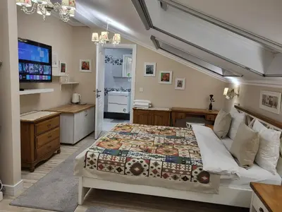 a bedroom with a bed and a desk and a television at Hotel Odeon in Plovdiv