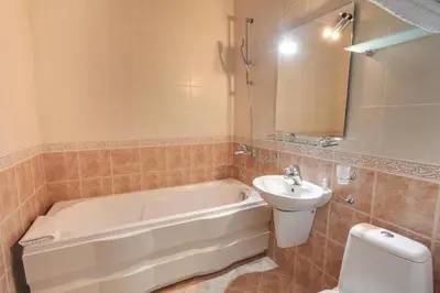 a bathroom with a tub and a sink and a toilet at Hotel Odeon in Plovdiv