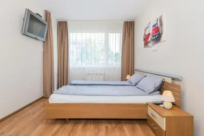 a bedroom with a bed and a tv on a wall at The M Place by Flat Mаnager in Sofia