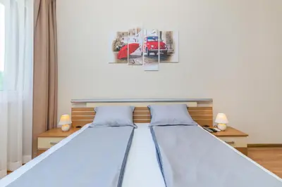 a bedroom with two beds and a picture of a car at The M Place by Flat Mаnager in Sofia