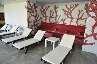 a row of white chairs and a red bench at 3 Mountains Hotel in Bansko