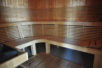 a wooden bench in a room with wooden walls at 3 Mountains Hotel in Bansko