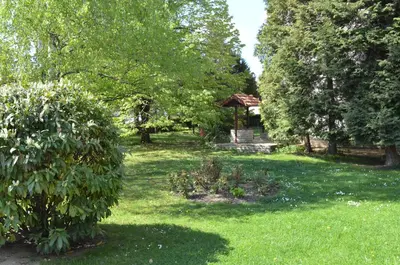 a garden with a gazebo and trees and grass at Hotel Bankya Palace in Bankya