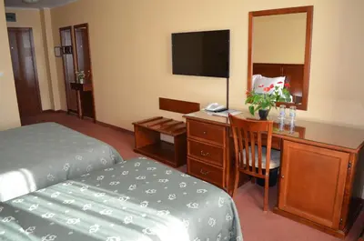 a hotel room with a bedroom with a desk and a bed at Hotel Bankya Palace in Bankya
