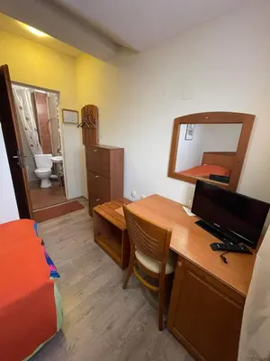 a room with a desk with a computer and a bed at Pirina Club Hotel in Bansko