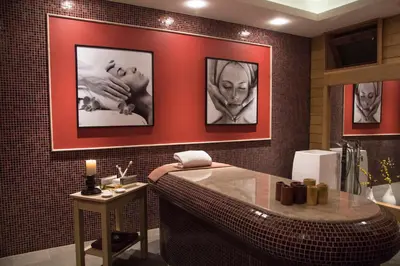 a bathroom with a tub and pictures on the wall at Family Hotel Delta in Ognyanovo