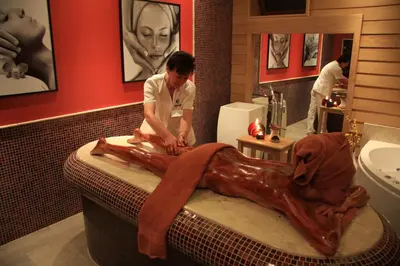 a man in a bathroom with a dog laying in a sink at Family Hotel Delta in Ognyanovo