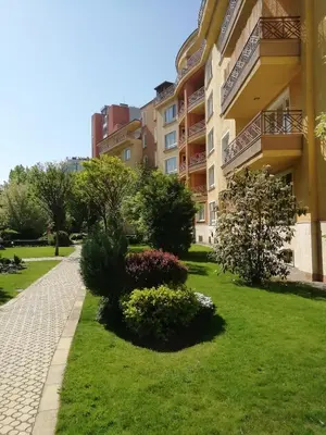 a apartment building with a green lawn and bushes at Aparthouse Borovo near Bulgaria Mall, free street parking in Sofia