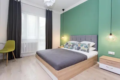 a bedroom with a bed and a green wall at The Cozy Apartment, Sofia in Sofia