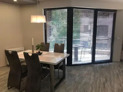 a dining room with a table and chairs and a large window at Apartment Trimontium 2 in Plovdiv