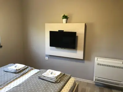 a bedroom with a flat screen tv on the wall at Apartment Trimontium 2 in Plovdiv