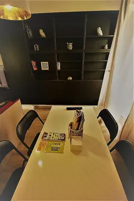 a table with chairs and a book on it at St. Seraphim's Apartment in Sofia