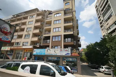 a tall building with cars parked in front of it at St. Seraphim's Apartment in Sofia