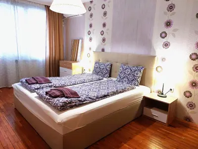a bedroom with a bed with blue and purple pillows at Fresh Apartment in Sofia