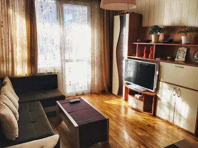 a living room with a couch and a tv at Fresh Apartment in Sofia