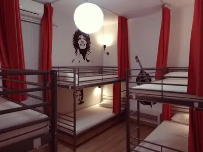 a room with three bunk beds with red curtains at Pijama Hostel in Plovdiv