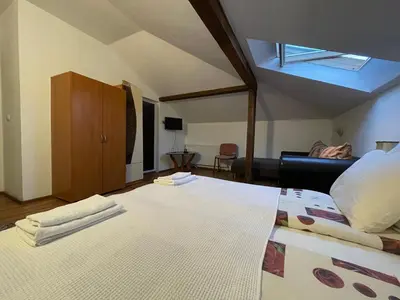 a bedroom with a large bed with a ceiling at Guest house Elit in Dobrinishte
