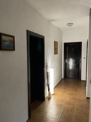 a hallway with two black doors and a tile floor at Guest house Elit in Dobrinishte
