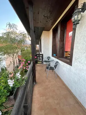a balcony of a house with a table and chairs at Guest house Elit in Dobrinishte