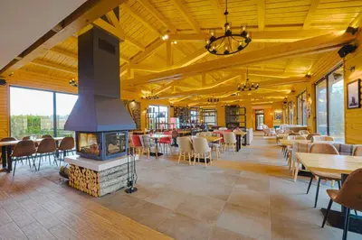 a restaurant with a fireplace and tables and chairs at Cornelia Deluxe Residence in Bansko