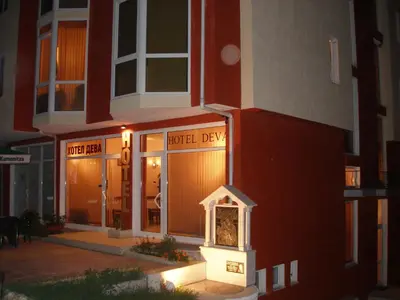 a building with a clock in front of a building at Hotel Deva in Sandanski