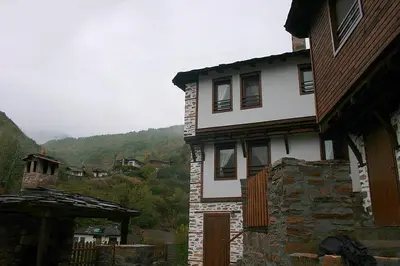 a large white house with a stone building at Complex Kosovo Houses in Kosovo