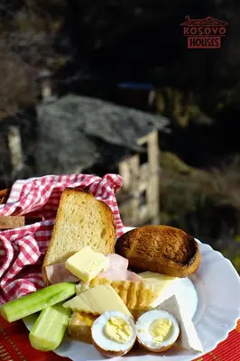 a plate of food with eggs bread and toast at Complex Kosovo Houses in Kosovo