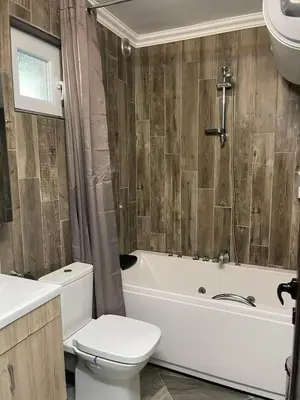 a bathroom with a toilet and a tub and a sink at Villa SUNRISE in Dospat