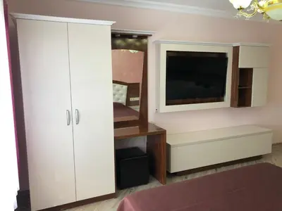 a bedroom with a white cabinet and a tv at Villa SUNRISE in Dospat