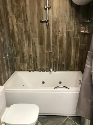 a white tub in a bathroom with a toilet at Villa SUNRISE in Dospat