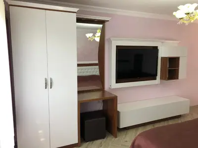 a bedroom with a tv and a white cabinet at Villa SUNRISE in Dospat