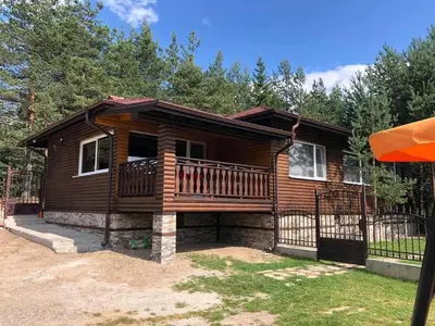 a log cabin with a large deck at Villa SUNRISE in Dospat
