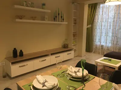 a living room with a table and a dining room at Evergreen Sofia Apartment in Sofia