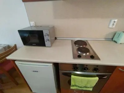 a kitchen with a stove and a microwave at New Inn in Bansko