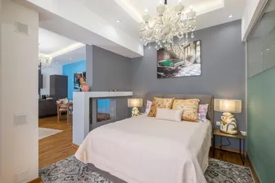 a bedroom with a bed and a chandelier at Parliament Sofia - Top Center Luxury Apartment in Sofia