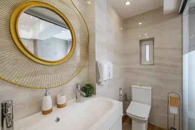 a bathroom with a sink and a mirror and a toilet at Parliament Sofia - Top Center Luxury Apartment in Sofia