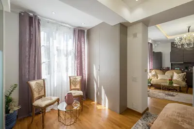 a living room with a couch and a table and chairs at Parliament Sofia - Top Center Luxury Apartment in Sofia