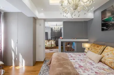 a bedroom with a bed and a chandelier at Parliament Sofia - Top Center Luxury Apartment in Sofia