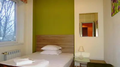 a bedroom with a bed with a green wall at Guest Rooms Kom in Sofia