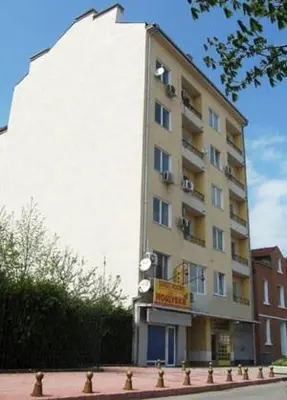 a tall white building with a sign in front of it at Guest Rooms Kom in Sofia