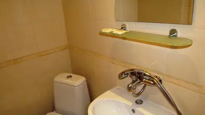a bathroom with a toilet and a sink and a mirror at Guest Rooms Kom in Sofia