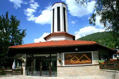 a building with a clock tower on top of it at Spa Hotel Planinata in Ribarica