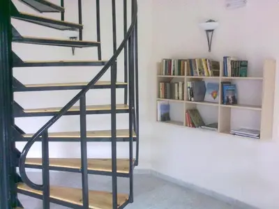 a spiral staircase in a room with book shelves at Spa Hotel Planinata in Ribarica