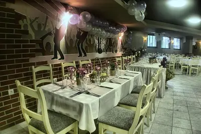 a dining room with white tables and chairs and a brick wall at Spa Hotel Planinata in Ribarica
